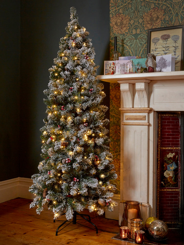 Illuminate your holidays with a 6ft Pre Lit Christmas Tree, featuring the Snowy Slim Windsor design.