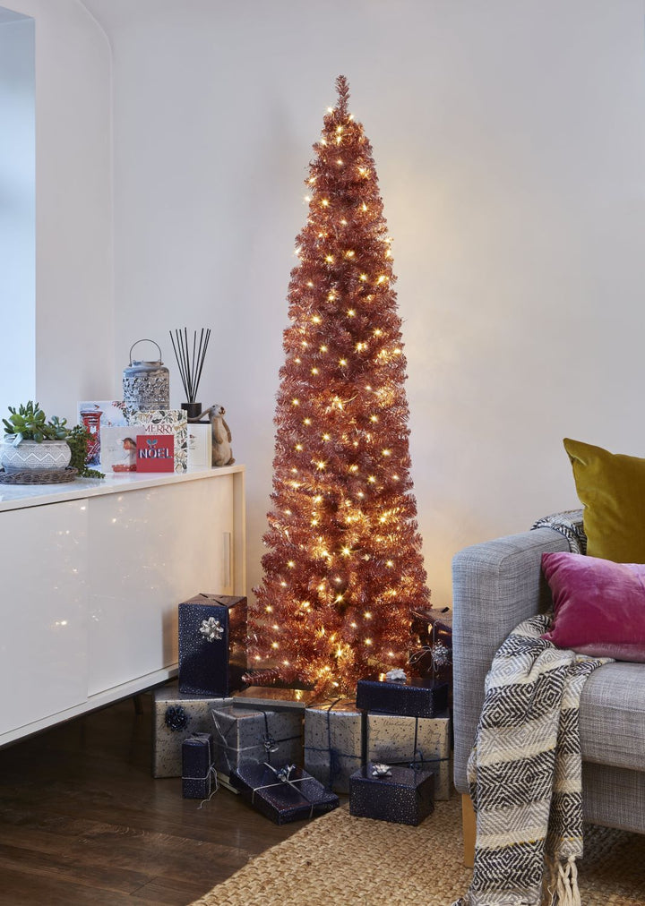 Bring a touch of luxury to your holiday decor with a 6ft Rose Gold Pencil Christmas Tree, pre lit for convenience.