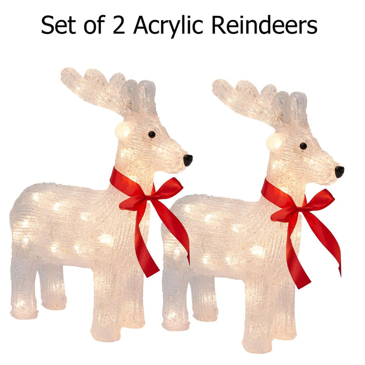 Acrylic reindeer sculpture amidst a snowy Christmas scene.