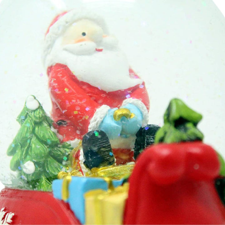 Celebrate the season with the joy of winter, portrayed in this Santa & Child Sledging snow globe.