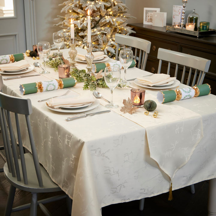 Creamy tablecloth adorned with non-metallic deer motif, perfect for a festive Christmas dinner by Celebright.
