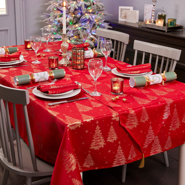 Metallic gold and silver Christmas tree patterned tablecloth on a festive holiday table setting