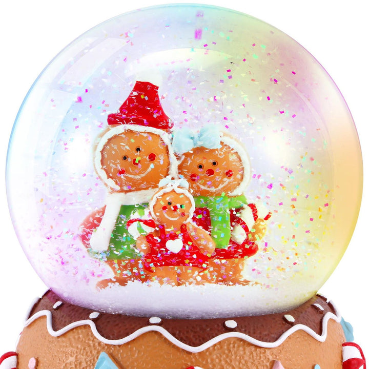Detailed close-up of the Gingerbread Family inside the Musical Snowglobe. Witness the charm of the holiday figures amidst a snowy wonderland.