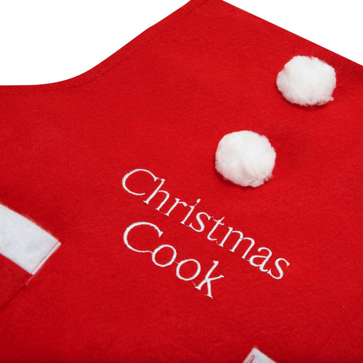 A red apron for Christmas cooking, adorned with an embroidered cook motif.