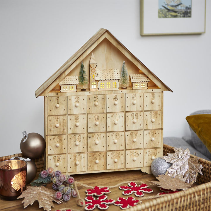 A festive wooden village advent calendar, a delightful holiday tradition.