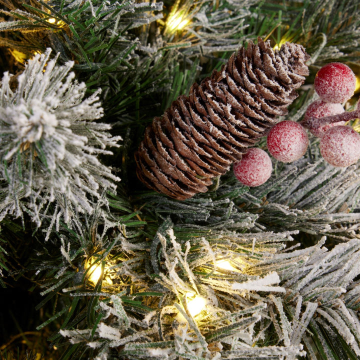 A 7ft snowy Windsor Christmas tree aglow with 900 warm white micro LED lights, capturing the essence of joyful festivities.