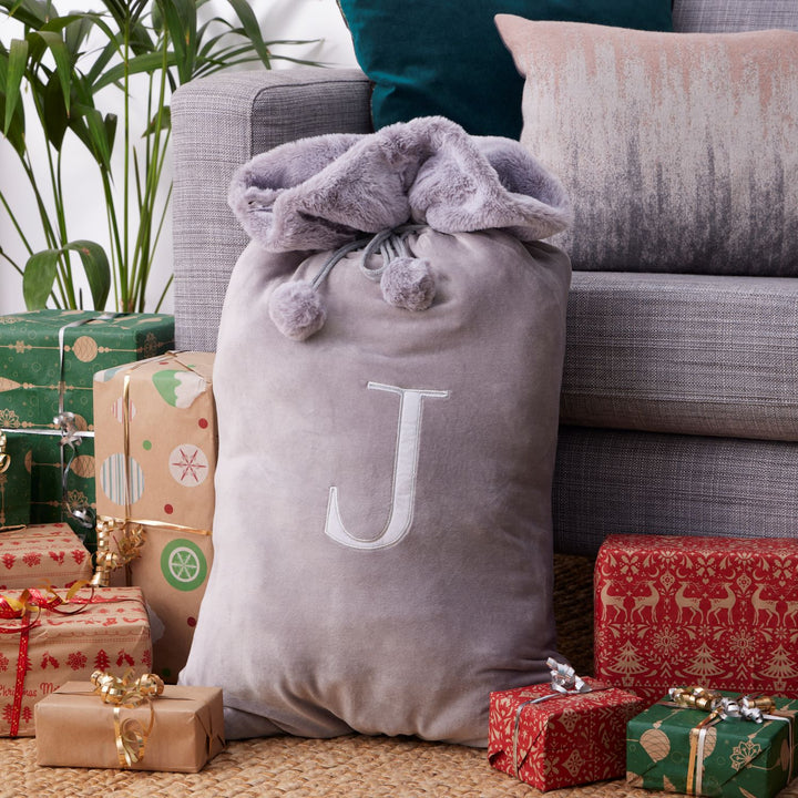 A light grey sack with a monogrammed letter A, J, L, M, or S, measuring 60cm in height and 45cm in width, made from 100% polyester.