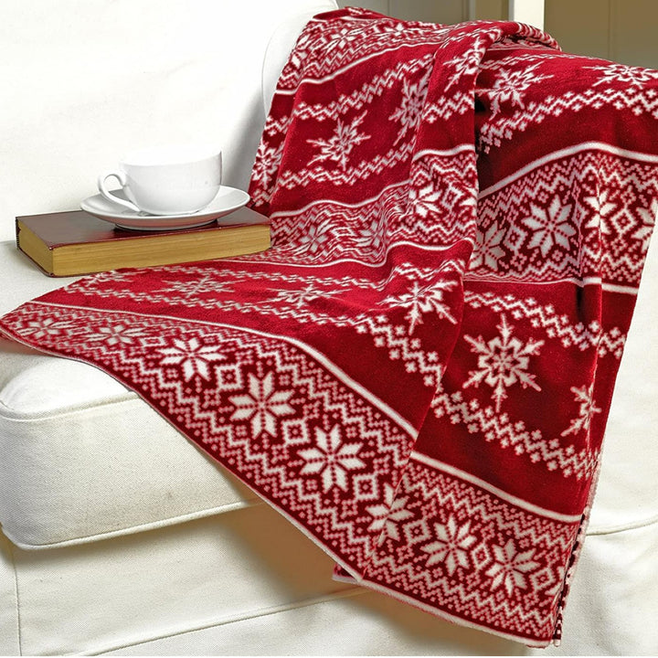 A luxurious red fleece throw with a Scandi Nordic design, adding chic design accents to your living and bedroom decor during the Christmas season.