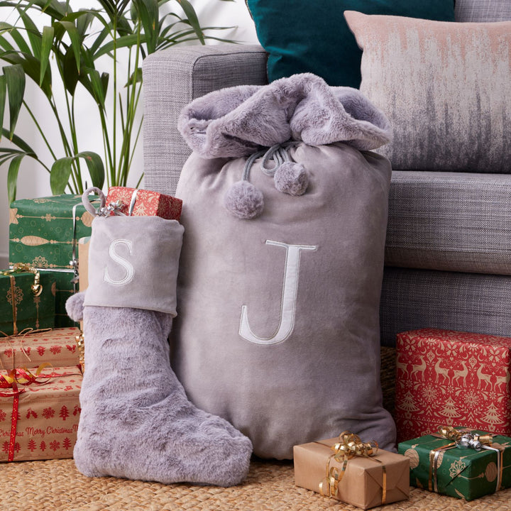 A combination of a light grey sack and stockings, elegantly monogrammed with letters A, J, L, M, or S, adding a touch of sophistication to your holiday decor.