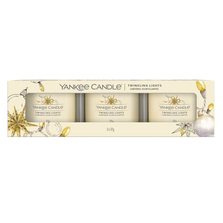 A trio of Twinkling Lights Yankee Candle votives in festive holders, emanating a cosy glow, perfect for holiday celebrations and relaxation.