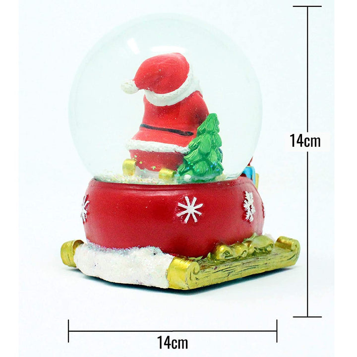 Add a touch of whimsy to your holiday decor with this Santa & Child Sledging snow globe.