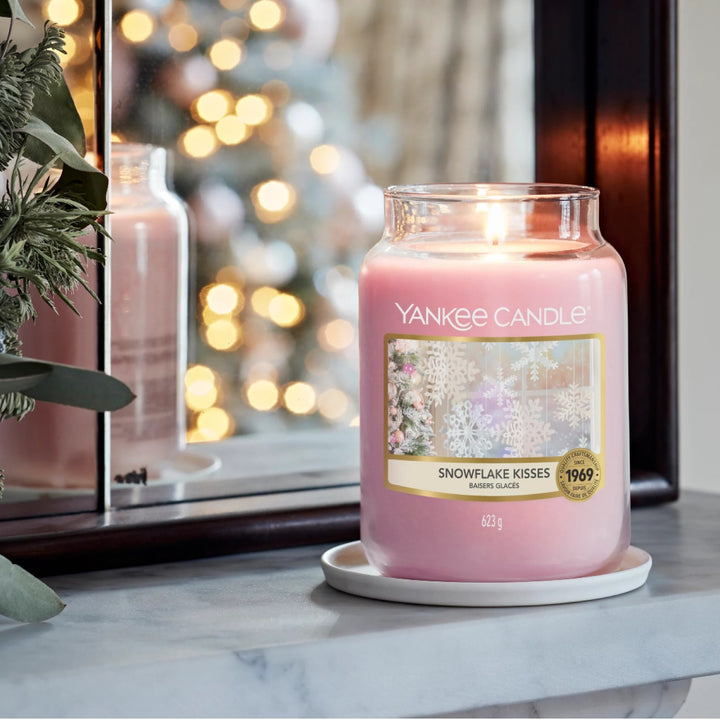 Indulge in the winter magic with Yankee Candle's Snowflake Kisses Large Jar, filling your home with powdery notes of violet, rose, and white musk for up to 150 hours.