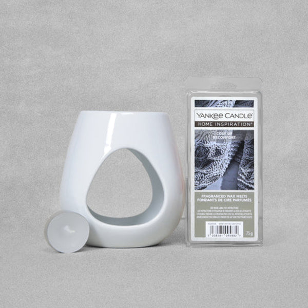 Elegant white ceramic wax melt warmer with 'Cosy Up' wax melts and tealight, creating a cozy holiday atmosphere.