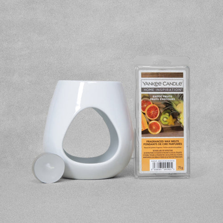 Yankee Candle Exotic Fruits Wax Melt Warmer Gift Set G-SS22: A white ceramic melt warmer with a curved top, accompanied by a 75g set of 'Exotic Fruits' wax melts and an unscented tealight, creating a relaxing ambiance.